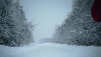 View of woman running on empty snowy road video