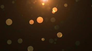Abstract background of yellow orange gold glowing particles and bokeh dots of festive energy magic, video 4k, 60 fps