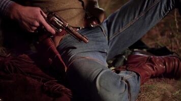 Cowboy pulls a revolver out of a holster. Life in the wild west of America. Close-up 4K video