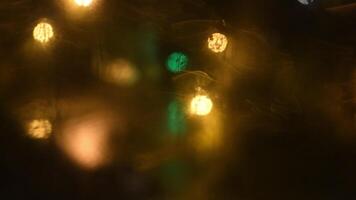 Intentional motion blur blinking lights. Blurry dirty glass window with golden and green bokeh lights of night city traffic. Dark abstract background video