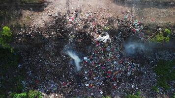 Burning dump in Asia. Pollution by plastic rubbish on landfill, drone view. video